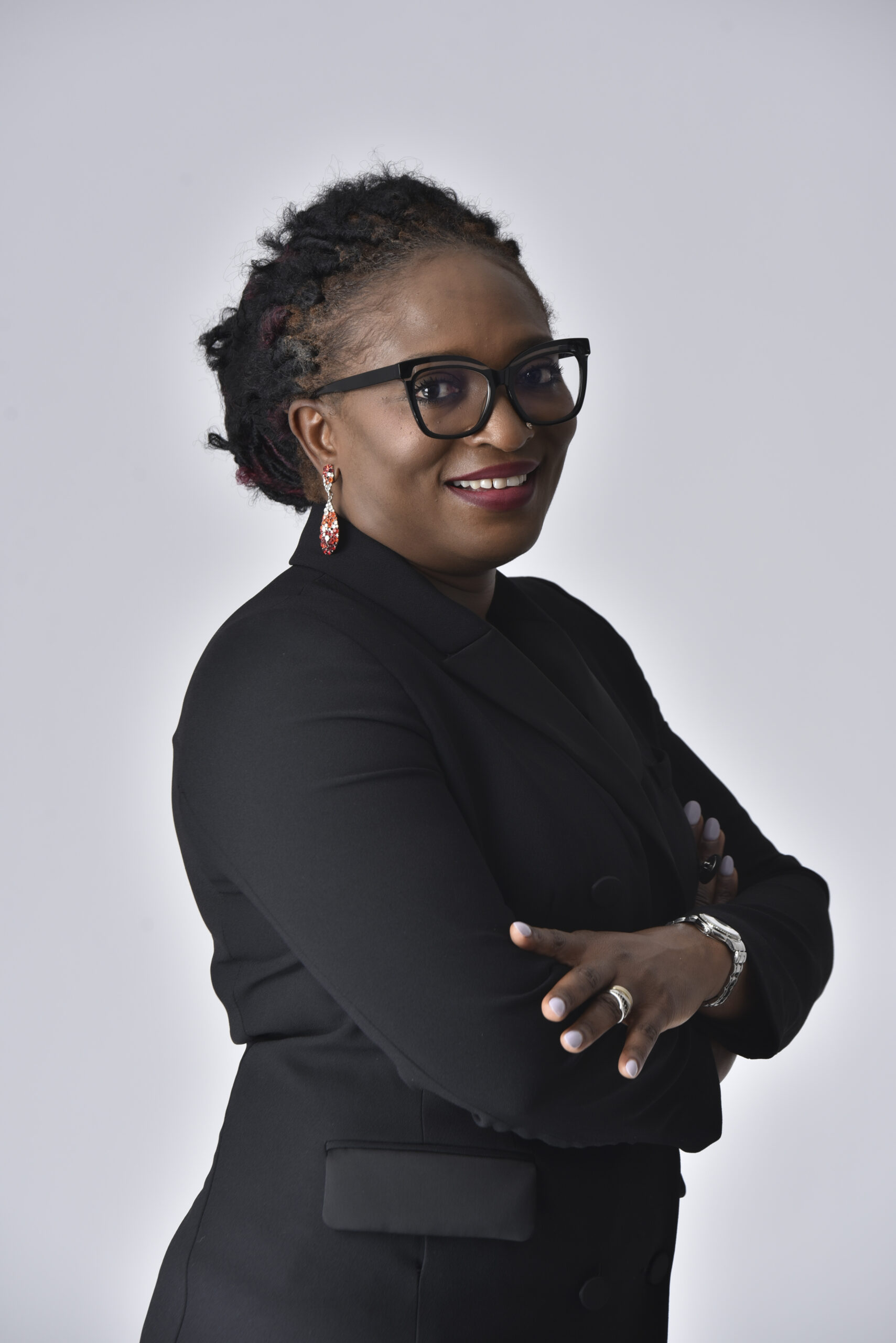 Bukola Jolugbo smiling warmly with arms crossed